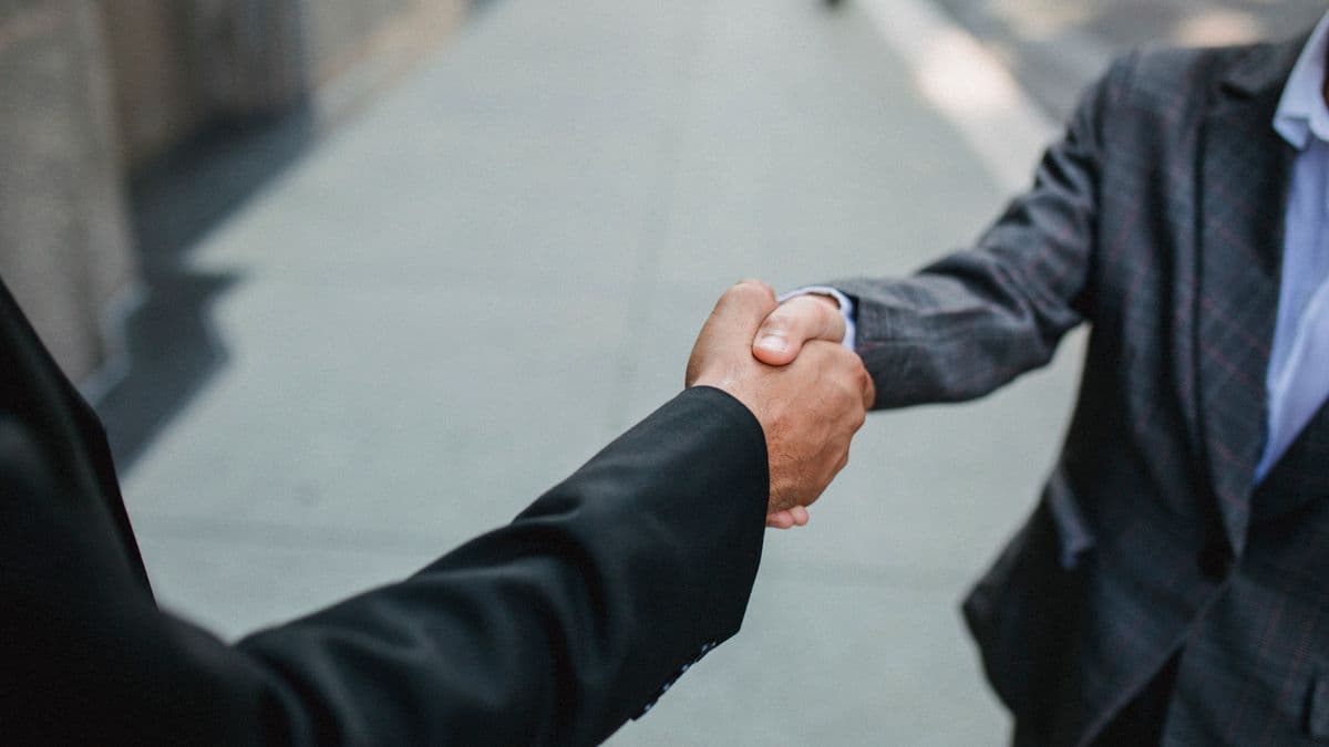 Two business people shaking hands outside an office