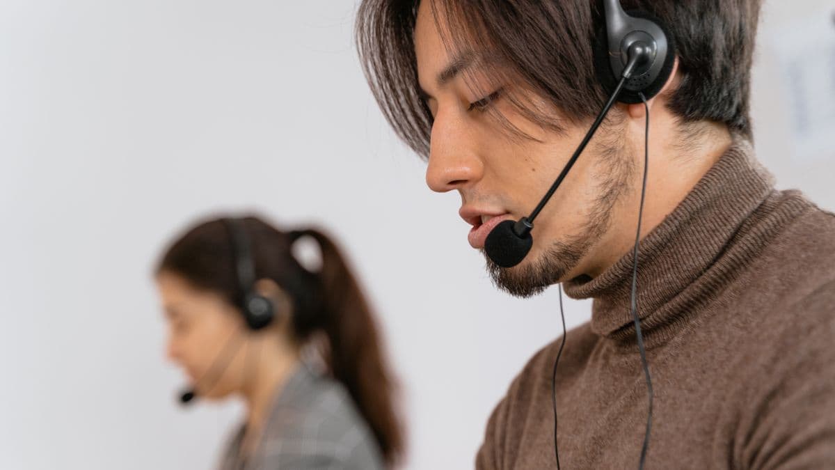 A customer support agent wearing a headset at a desk