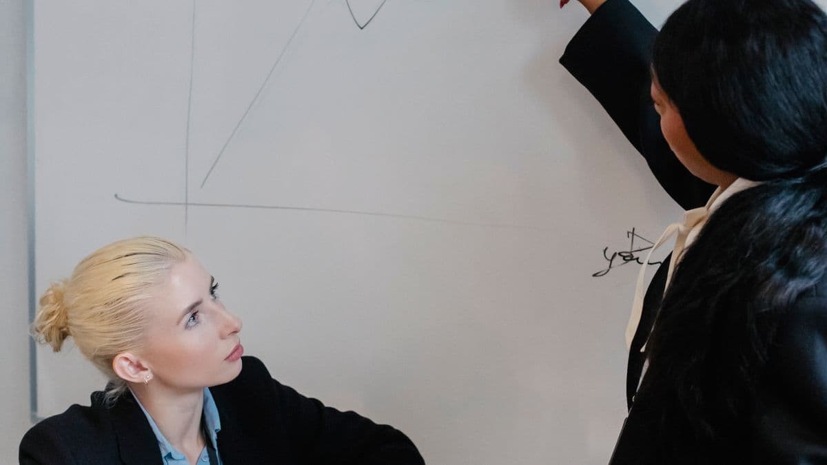 Two colleagues discussing a plan at a whiteboard