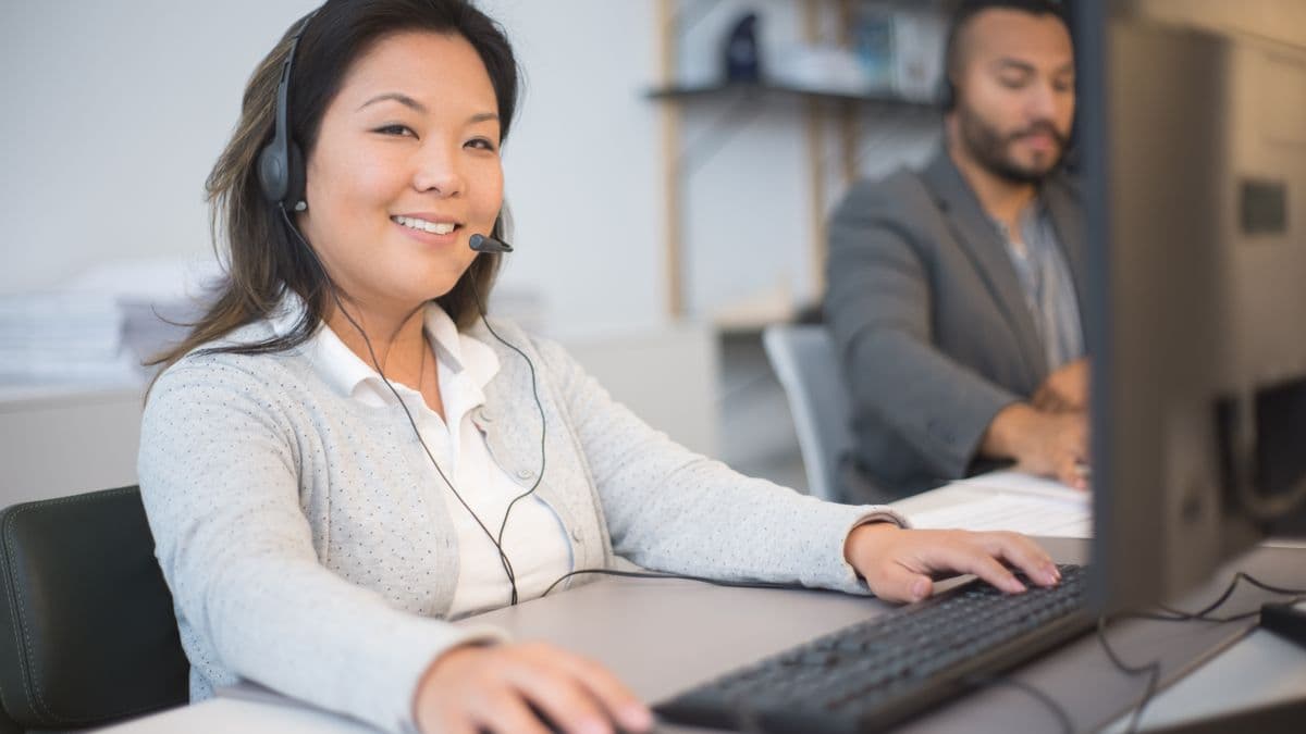 A friendly support agent smiling while helping a customer