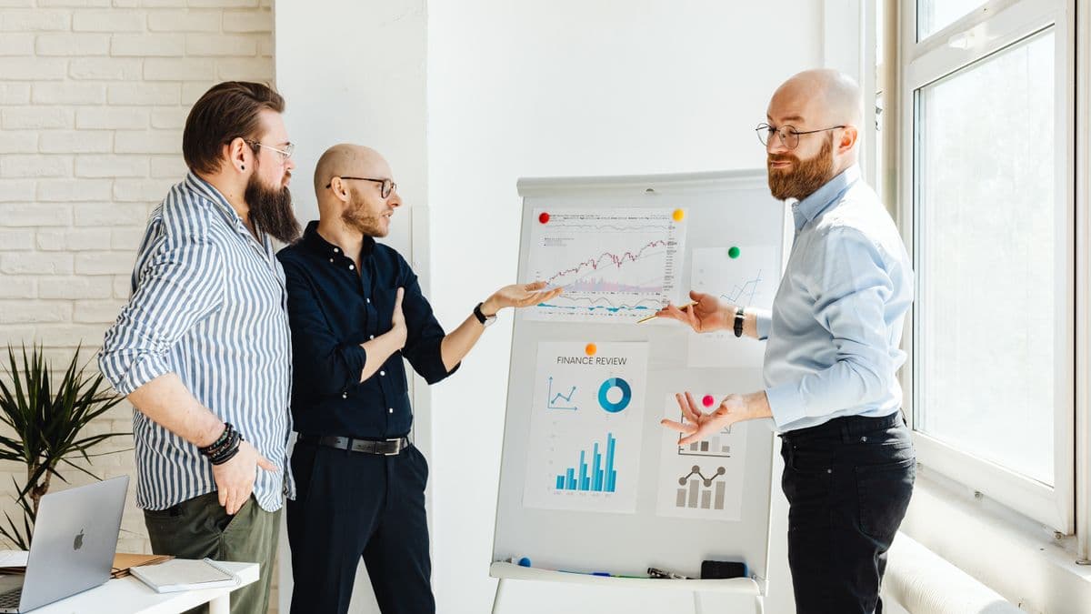 Business people reviewing finance charts on a whiteboard