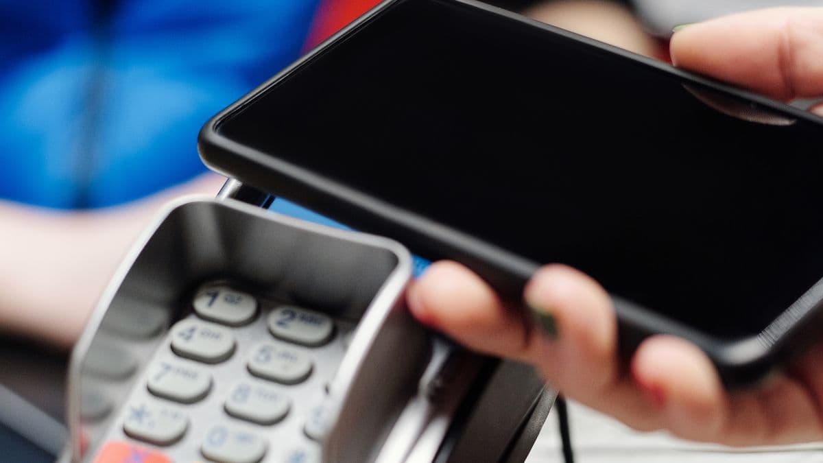 A customer paying with a phone on a card terminal
