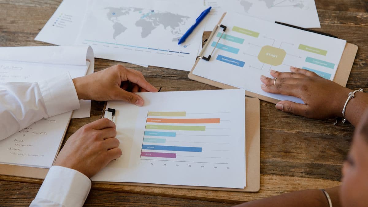 Hands reviewing charts and a planning flowchart on a desk