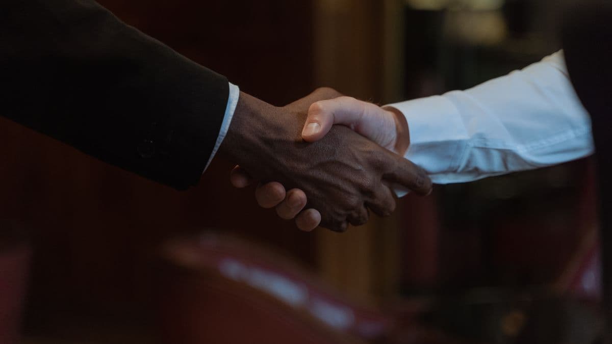 Two people shaking hands to close a business agreement