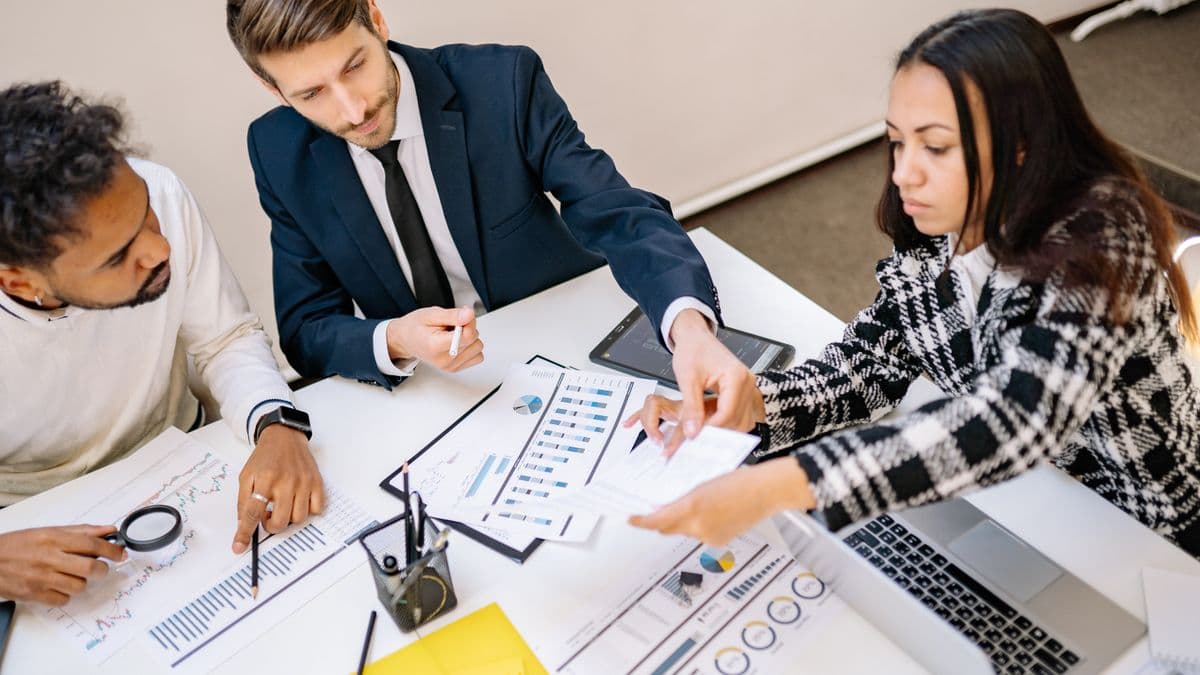 A business team reviewing client data and reports together at a desk
